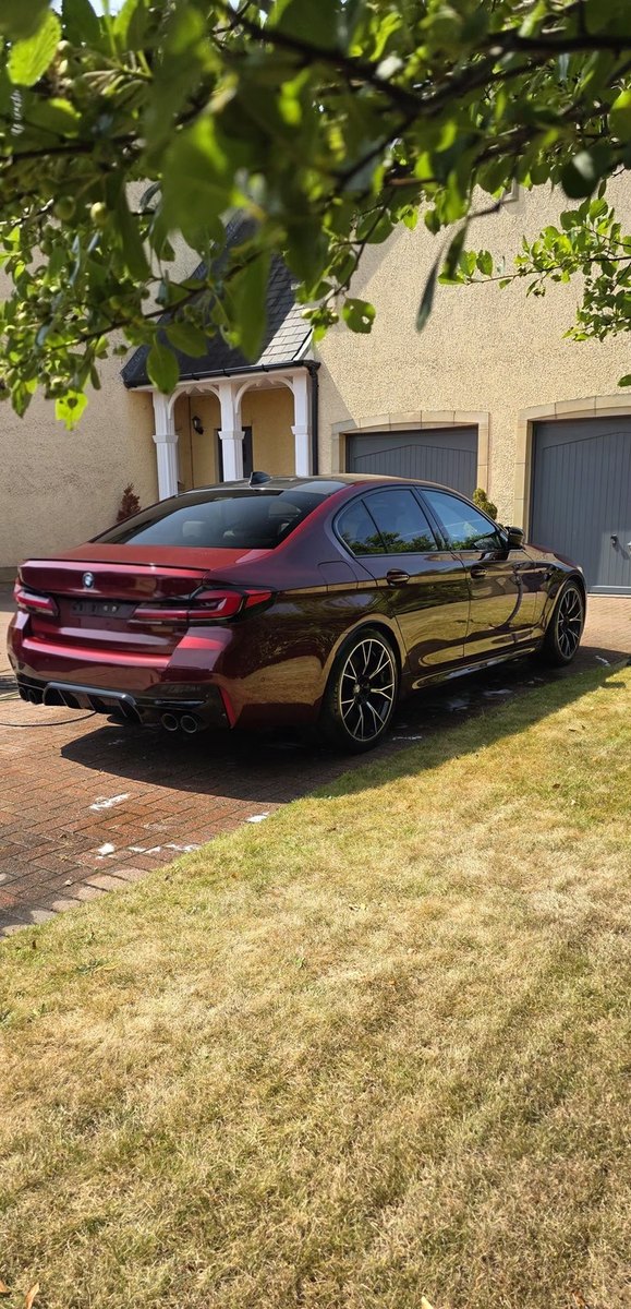 Red BMW M5 rear quarter after a full detail