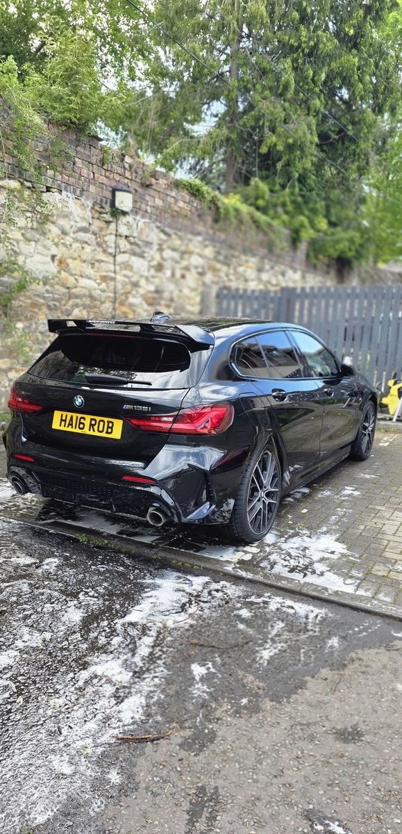 Black BMW M135i rear detailed on block paving